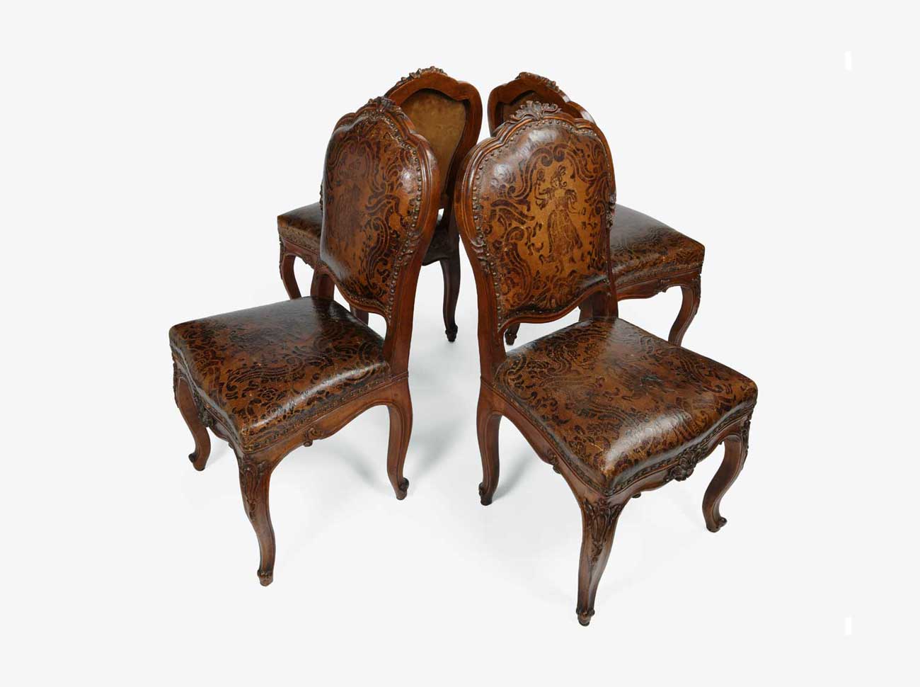 Quattro sedie di legno di noce intagliato con copertura di cuoio impresso